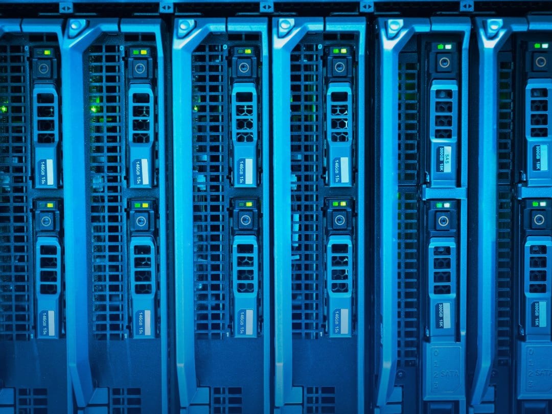 Rows of blue-lit server blades with drive bays in a data centre